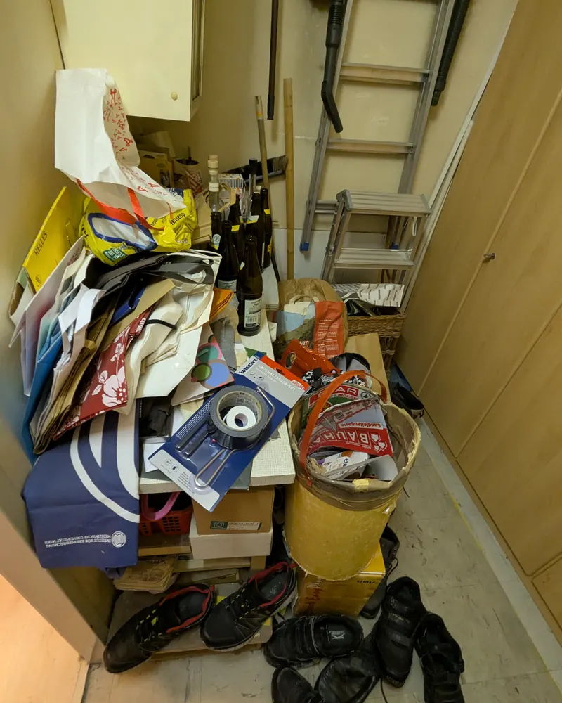 Vorzimmer vor dem Aufräumen: Taschen, Flaschen, Schuhe und eine Leiter auf engem Raum.