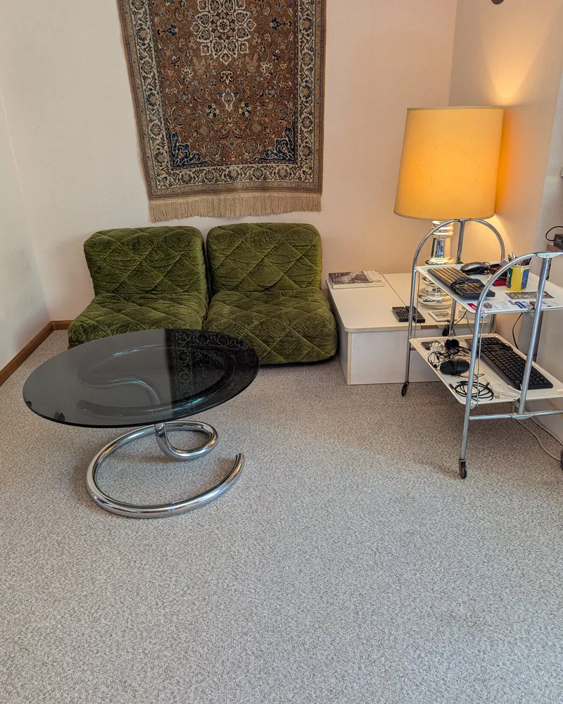 Wohnzimmer nachher: freier Glastisch vor der Sitzgarnitur, Lampe und Servierwagen an der Wand.